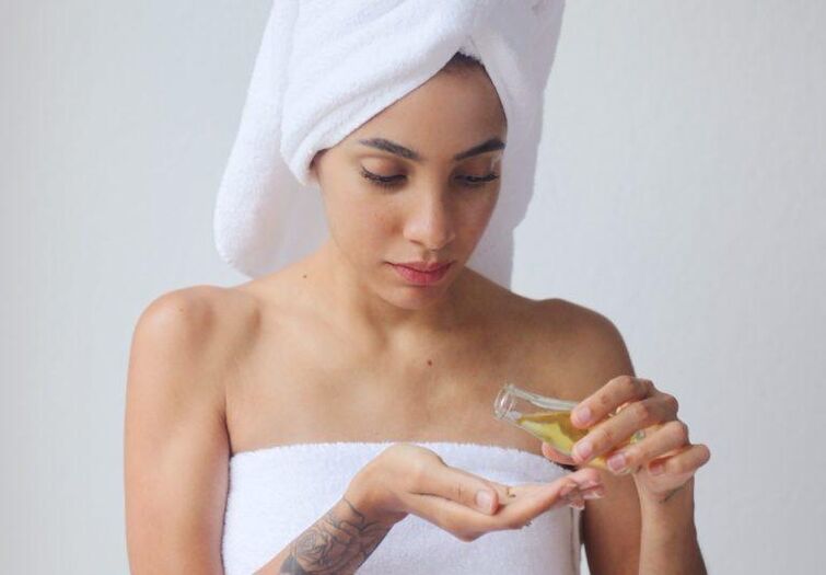 Una ragazza usa l'olio per ringiovanire la pelle